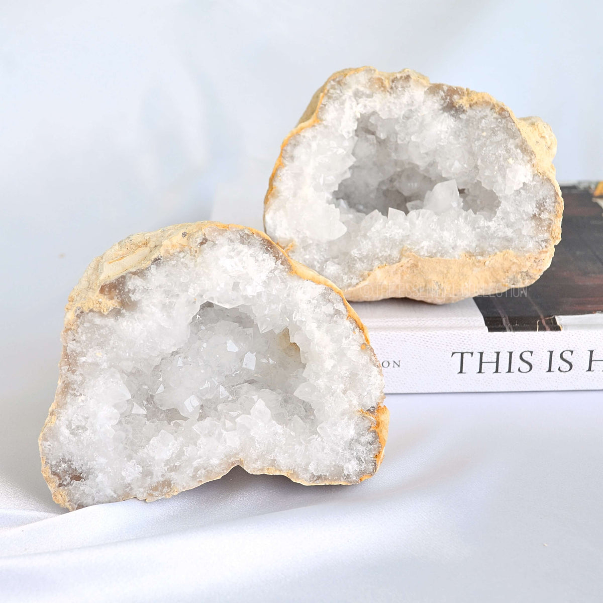 Two crystal geodes on a book with a white background