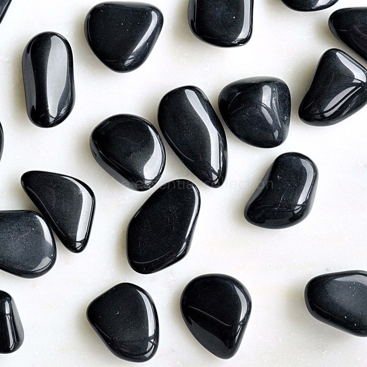 black obsidian tumbled crystals australia white background