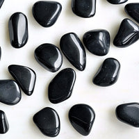 black obsidian tumbled crystals australia white background