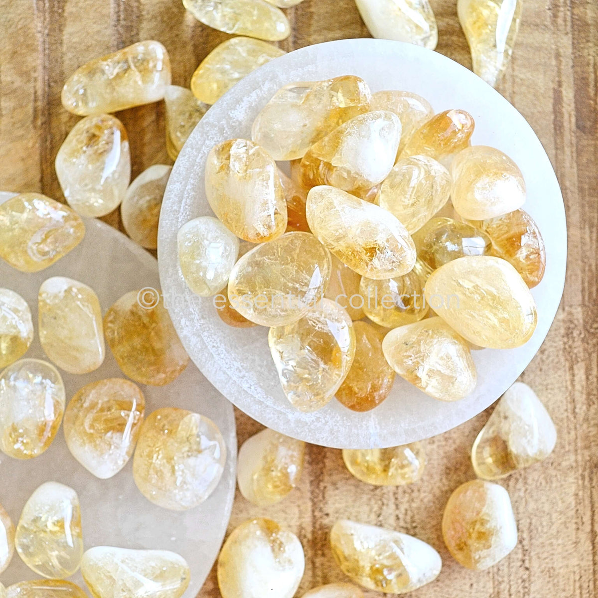 bright yellow citrine tumbled crystals in white selenite bowl bright shiny vibrant gemstones by the essential collection Australia