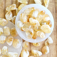 bright yellow citrine tumbled crystals in white selenite bowl bright shiny vibrant gemstones by the essential collection Australia