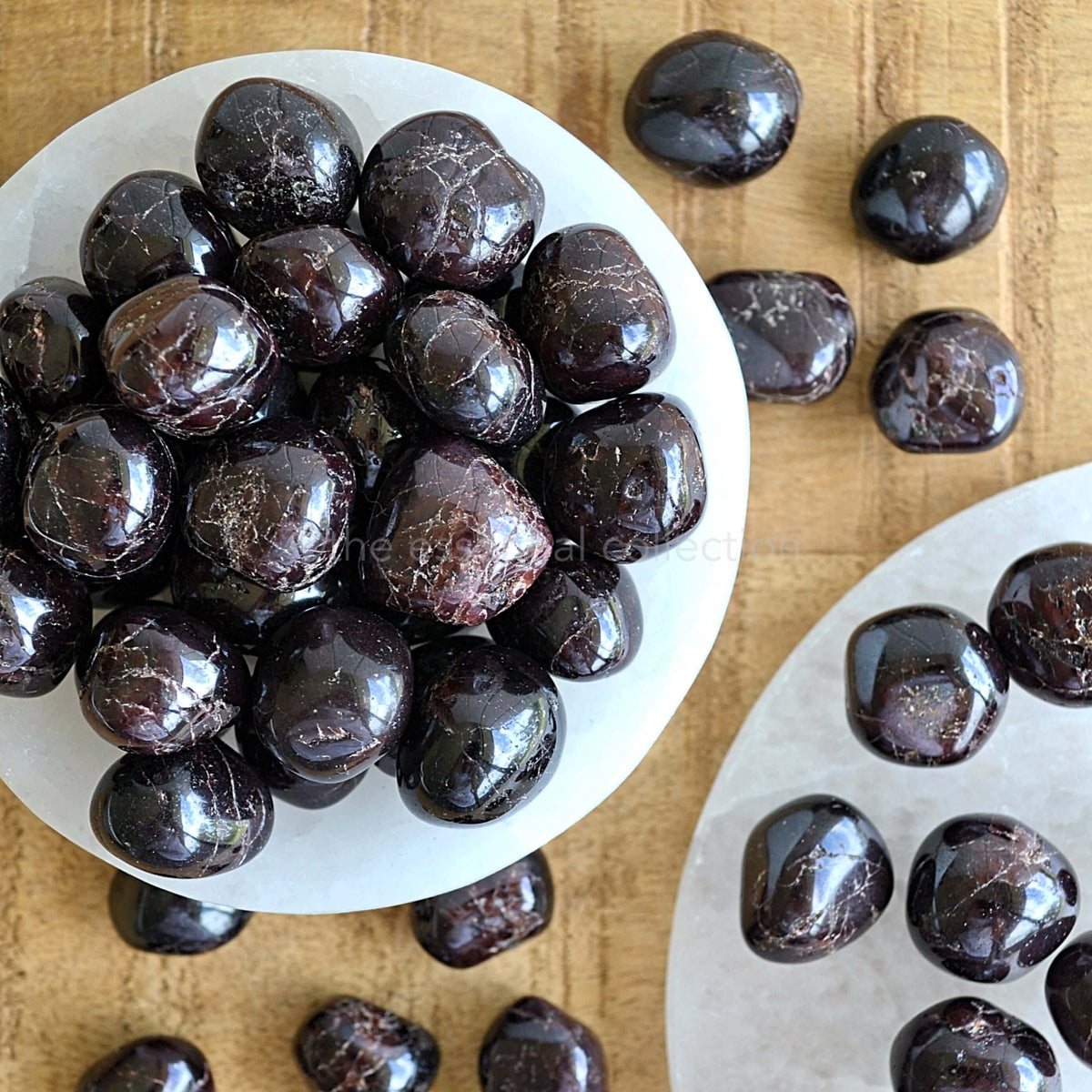 garnet tumbled crystal gemstones in white selenite bowl