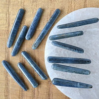 kyanite tumbled crystal sticks on white selenite plate