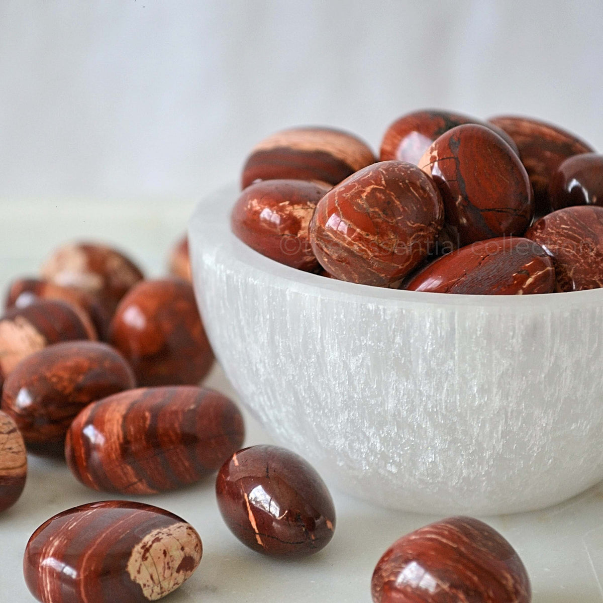 snakeskin jasper tumbles tumbled crystals in white selenite bowl white background
