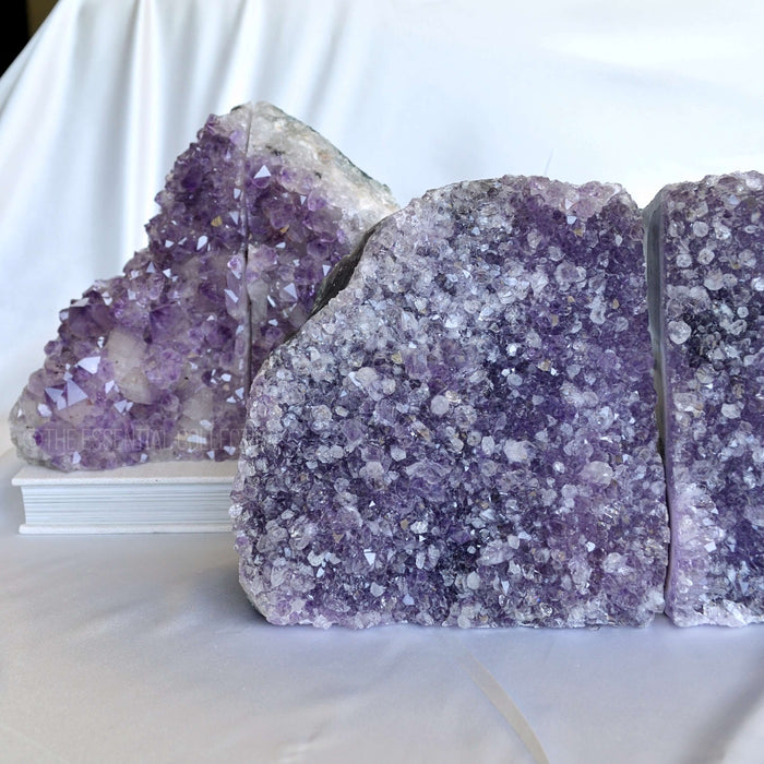 Amethyst crystal bookends on a white surface with a white curtain background