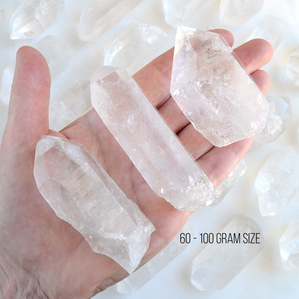 hand holding raw clear quartz points with white background