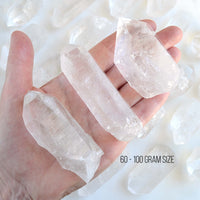 hand holding raw clear quartz points with white background