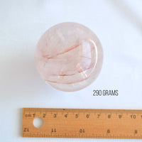 large shiny fire quartz sphere next to ruler
