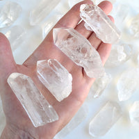 Hand holding clear crystal points with a white background