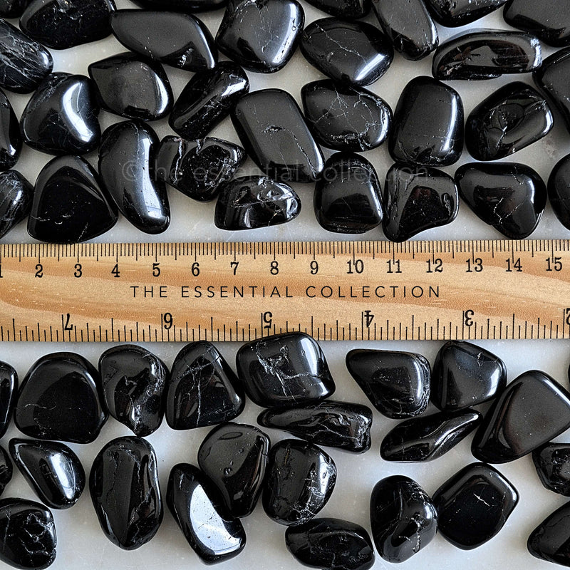 black tourmaline tumbled crystals with ruler showing size