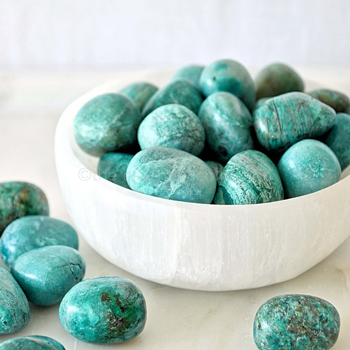 chrysocolla tumbles white background in white selenite crystal bowl bulk lot purchases from the essential collection australia