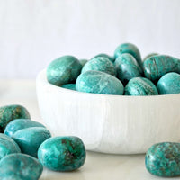 chrysocolla tumbled crystals deep turquoise colour from Peru in white selenite dish with white background sold by the essential collection australia