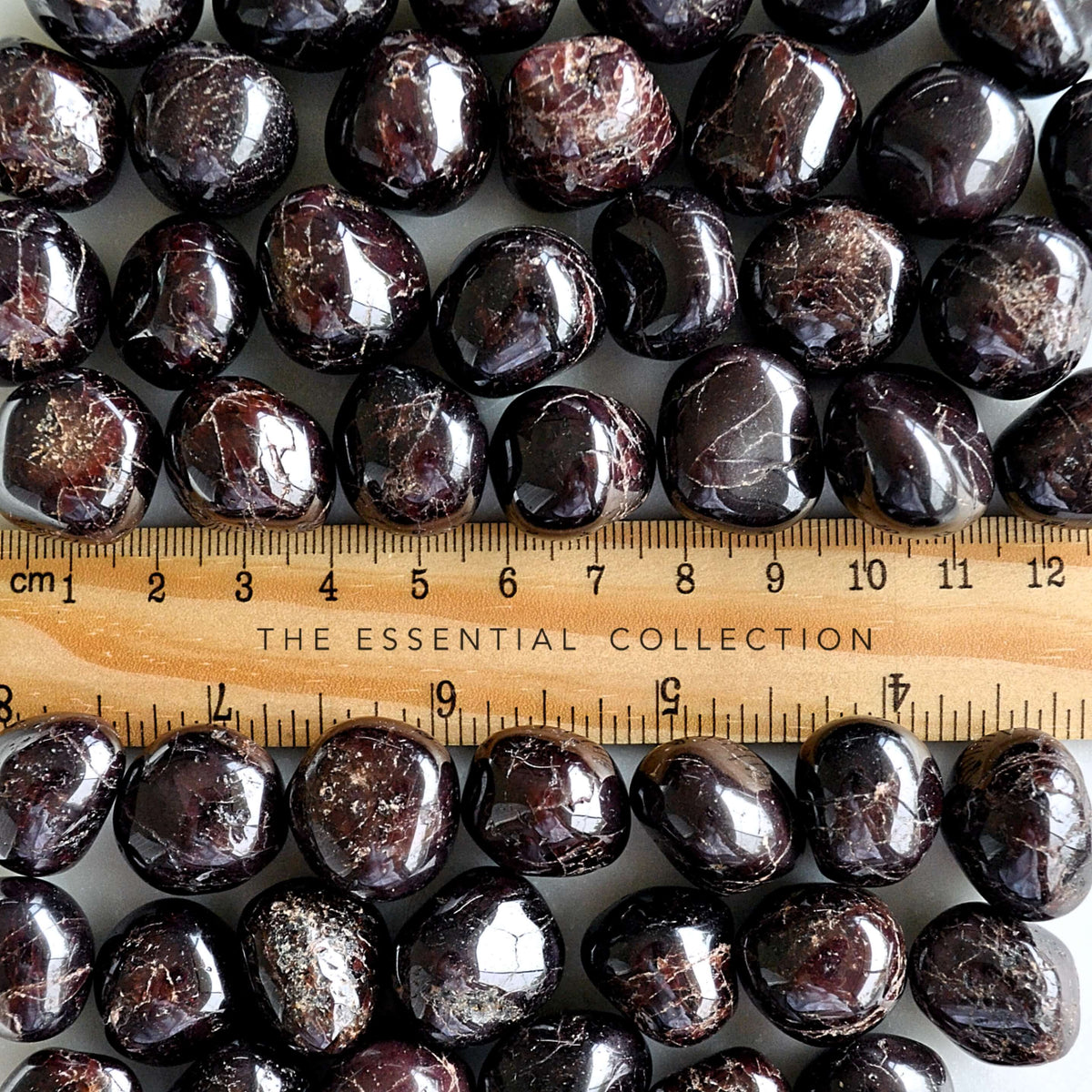garnet tumbled gemstone crystals with ruler showing size
