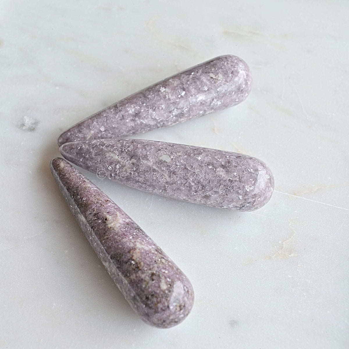 lepidolite crystals wands reiki tools white background