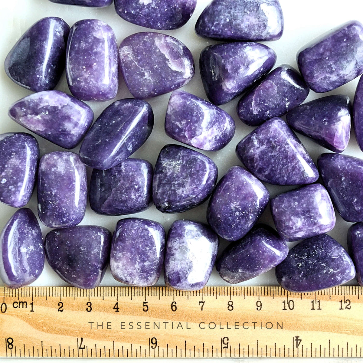 deep purple lepidolite tumbled crystals with ruler