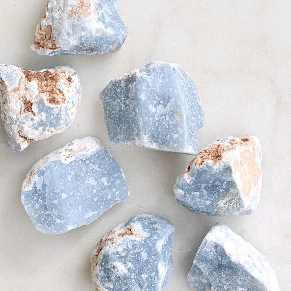 Raw angelite crystals on marble background