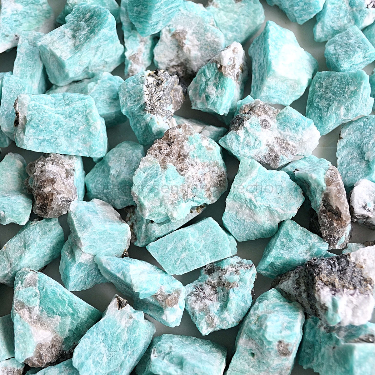 rough raw amazonite crystals in pile white background