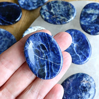 sodalite palm worry stone in hand showing size
